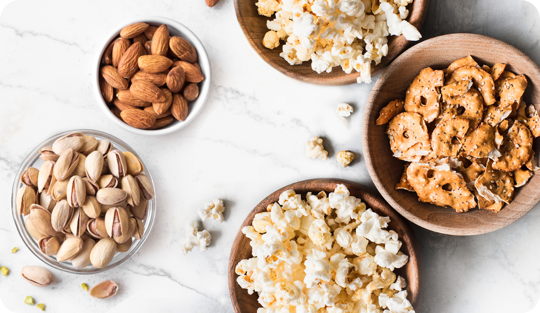 Bowls of popcorn and nuts on a table 