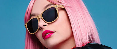 A woman with pink hair, singlasses and bright pink lipstick