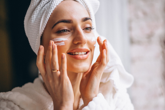 A woman applying moisturiser to her face