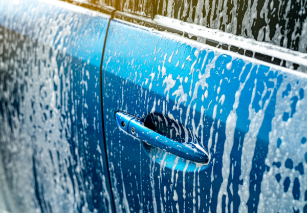 A blue car being washed with our new low environmental impact car shampoo