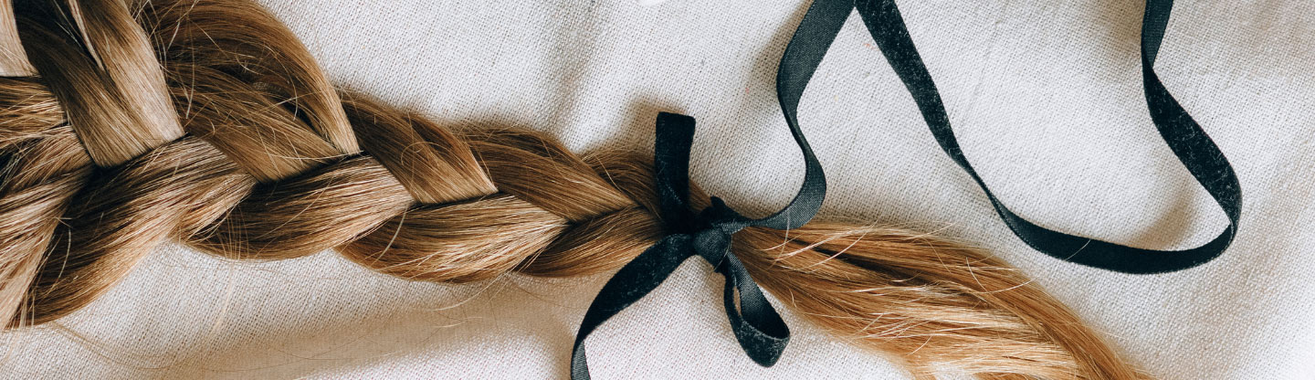 Braided hair tied with a black ribbon