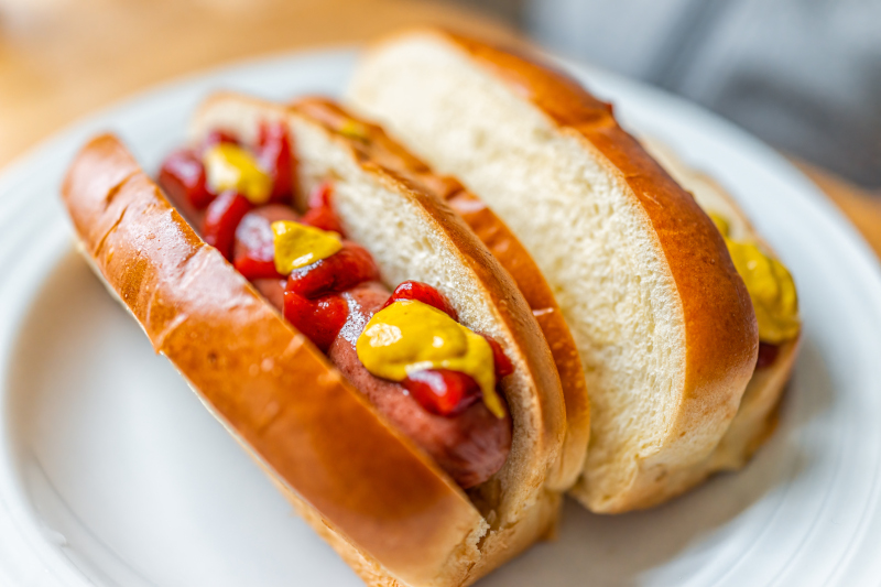 Meat-alternative hot dogs in rolls with mustard and tomato sauce