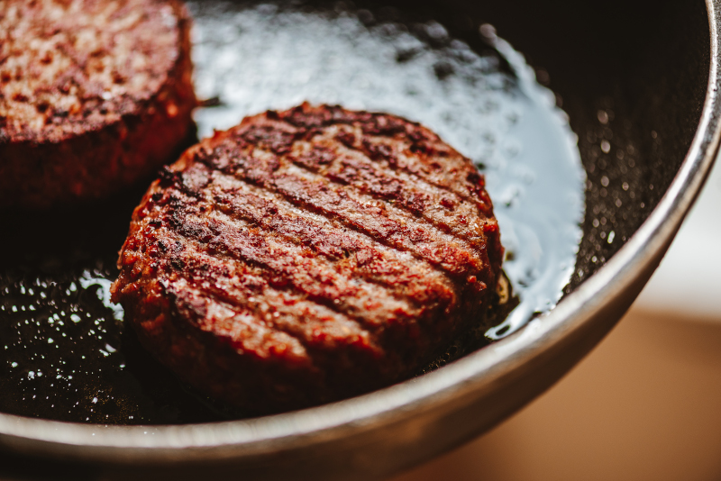 Sustainable meat-alternative burgers in a frying pan