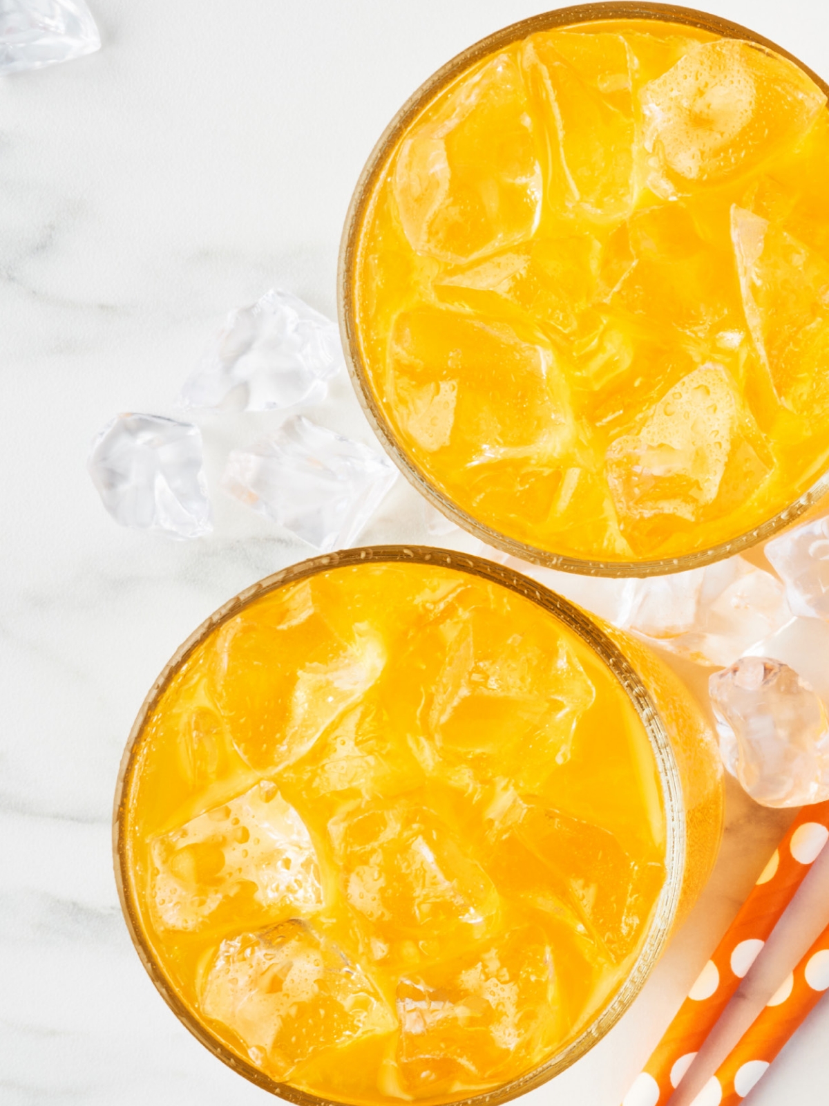 Orange beverages in glasses with ice