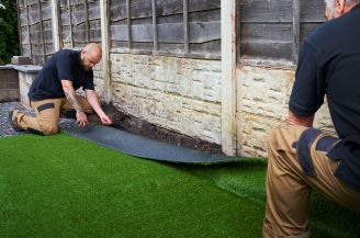 Two men installing artificial turf with water-based adhesive