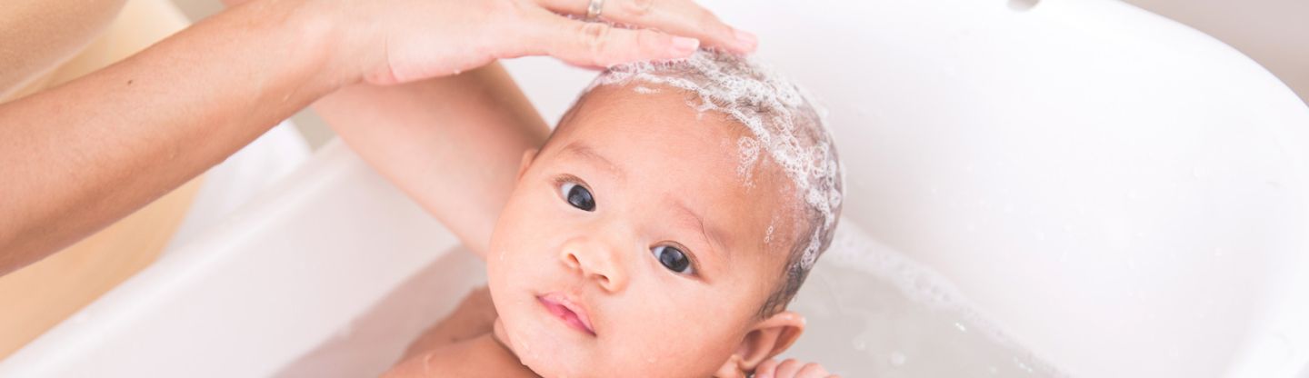 baby having it's hair washed in a bath