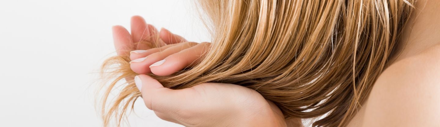 A close up of a woman holding her hair in her hands