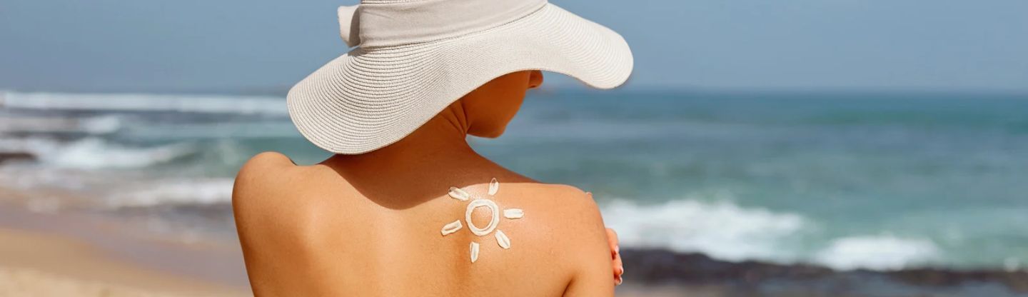 Women on a beach with sun shape on her back from sun cream