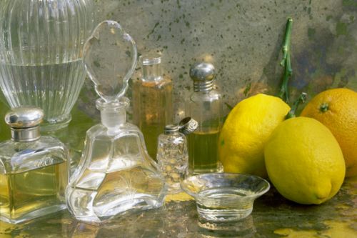 Fragrance bottles on a table surrounded by lemons