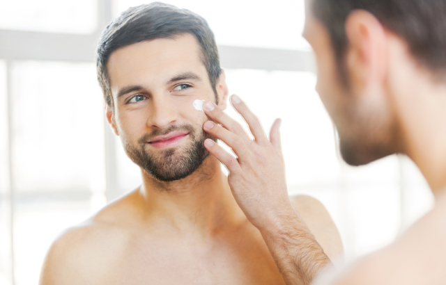 Man applying skin care lotion to his face