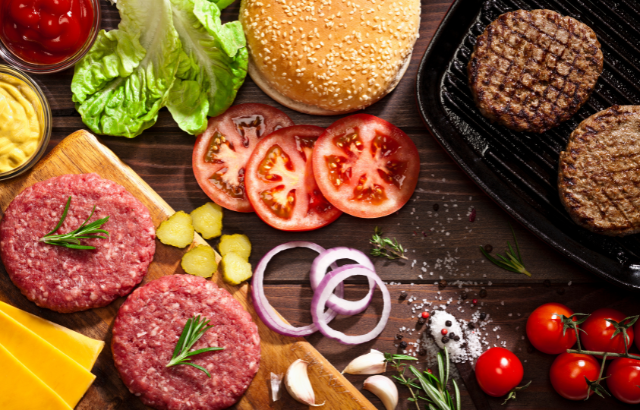 two meat patties with burger toppings surrounding it