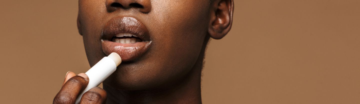 Woman applying lip balm to her lips