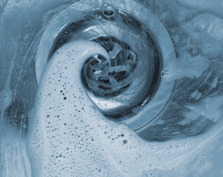 Soapy water swirling down a sink drain